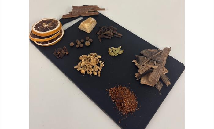 Botanical slate board filled with driend orange, cinnamon, cassia bark cardamom and others